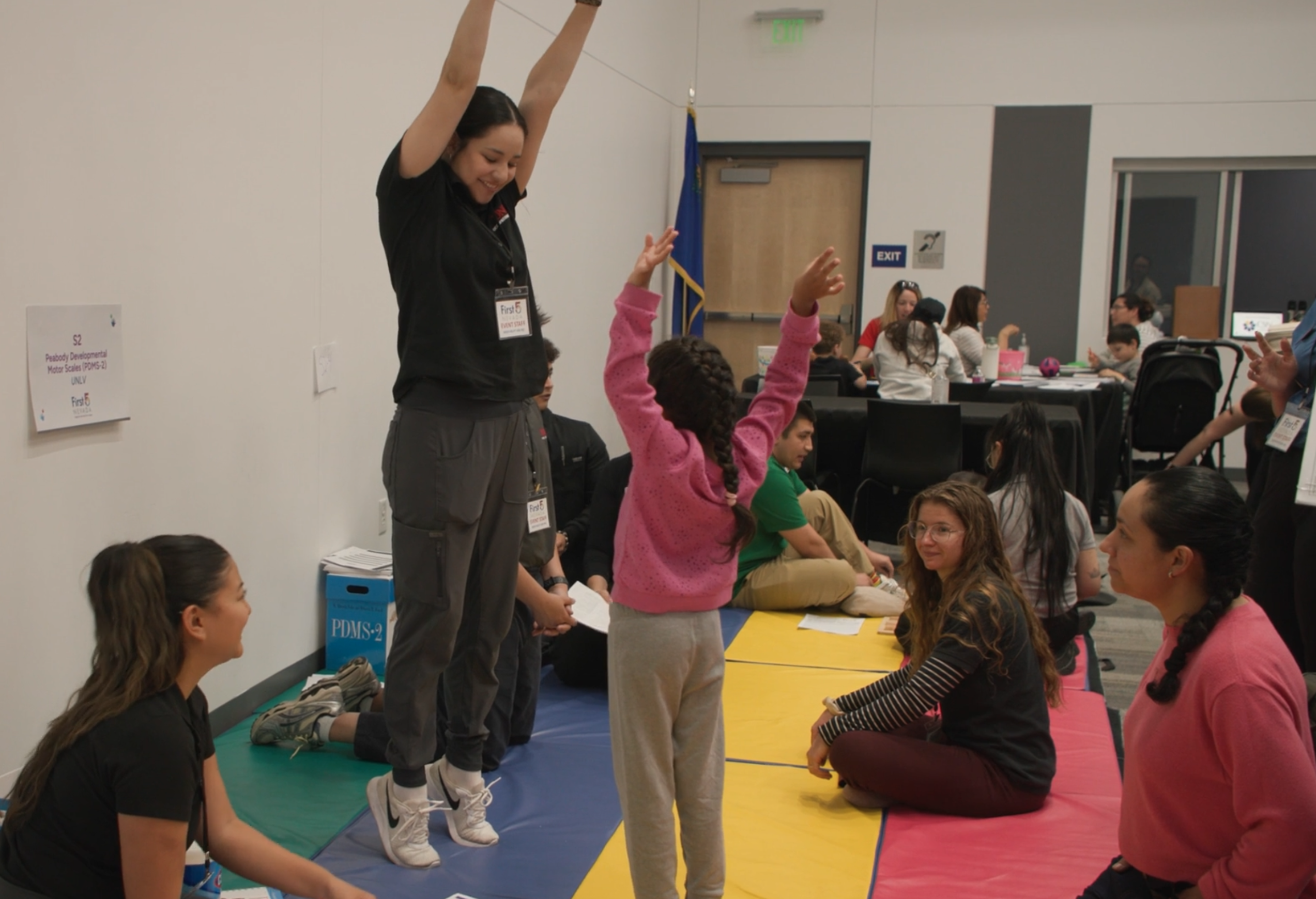 Women jumping in the air at a Screening event, young girl is doing the same