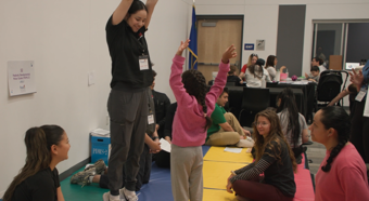 Women jumping in the air at a Screening event, young girl is doing the same