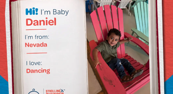 Baby Daniel smiling at camera sitting in big red chair.  