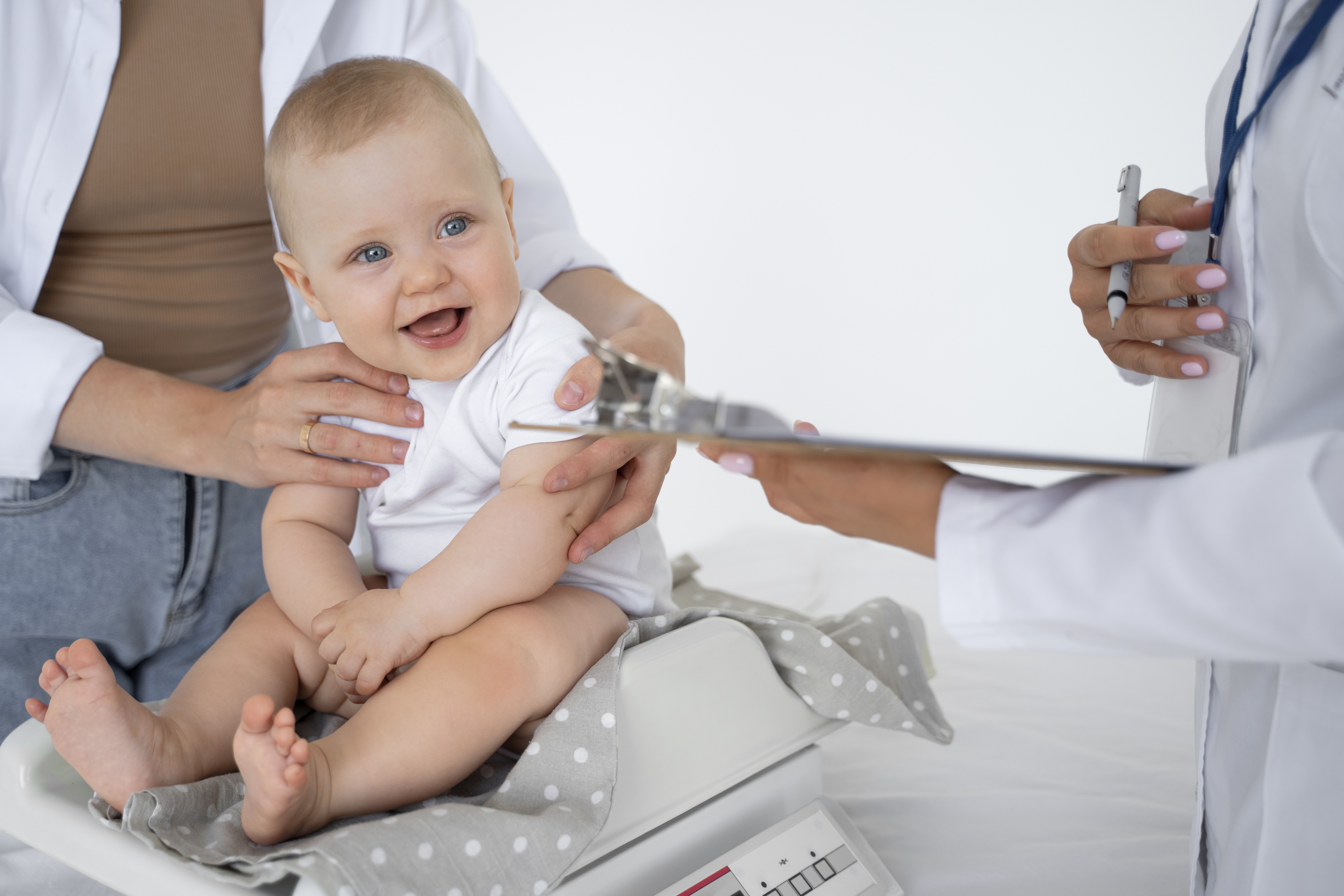 Baby at doctors office with big smile on his face.