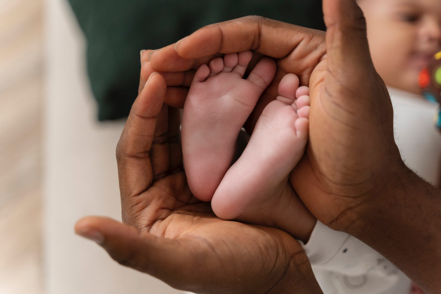 Closeup of a baby's feet, with adult hands holding the feet.